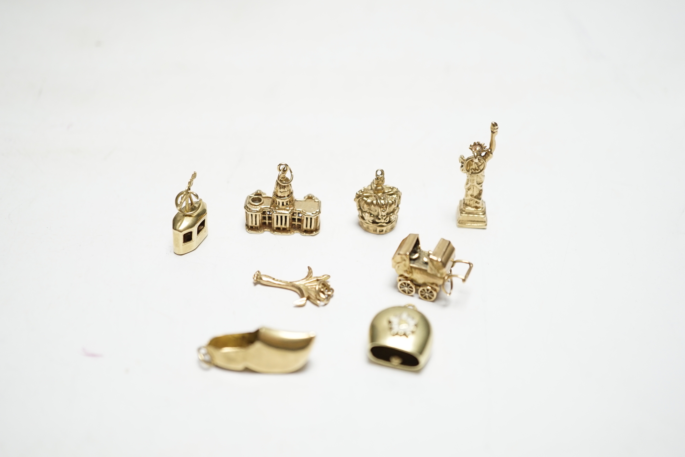A 585 'Cable car' charm, 1.4 grams, three 9ct gold charms, 9.9 grams and four other yellow metal charms, one with enamel, gross weight 12.5 grams.